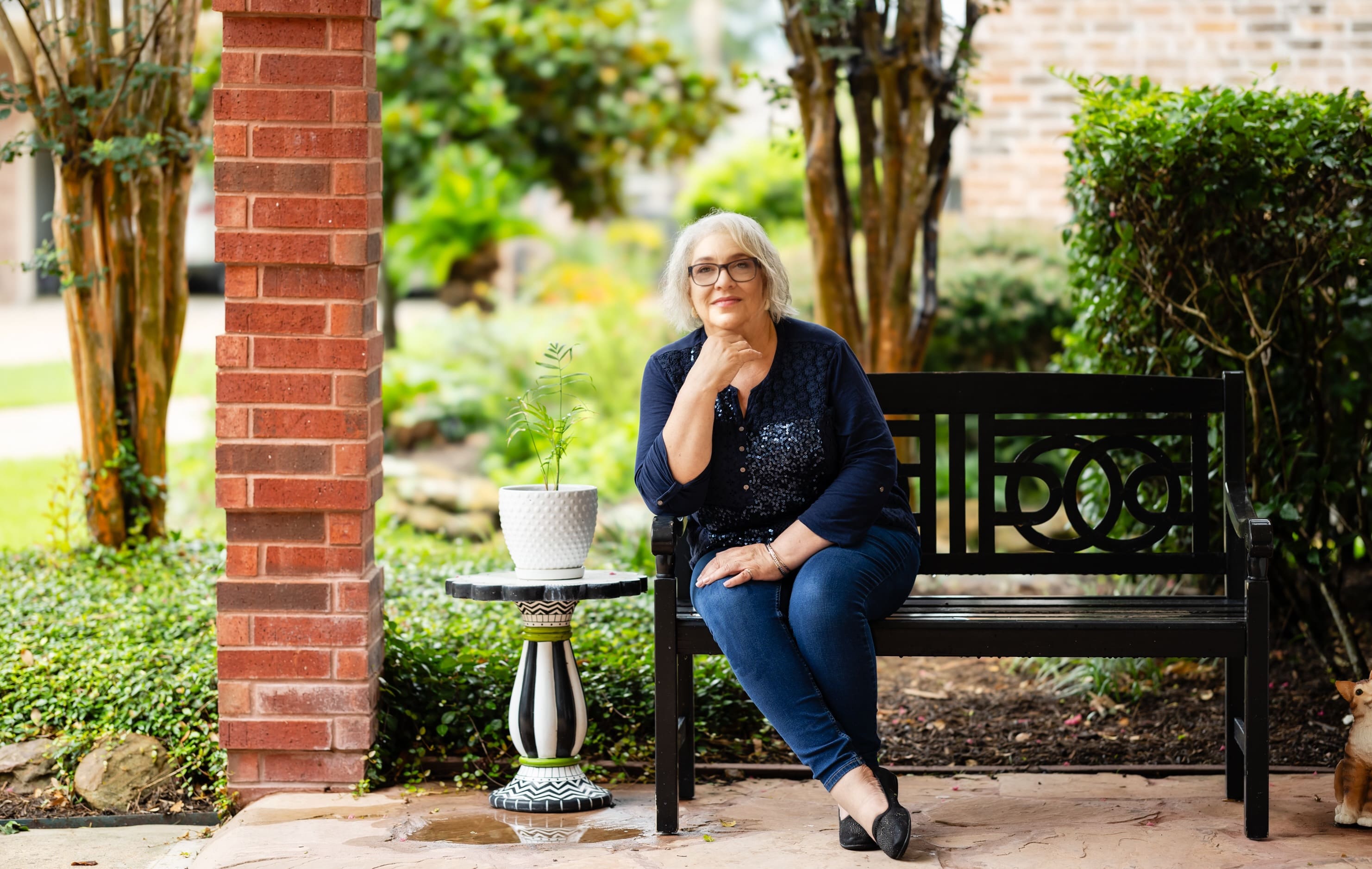 A woman sitting on the ground next to a table.