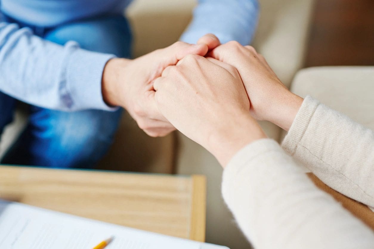 A man and woman holding hands in front of each other.